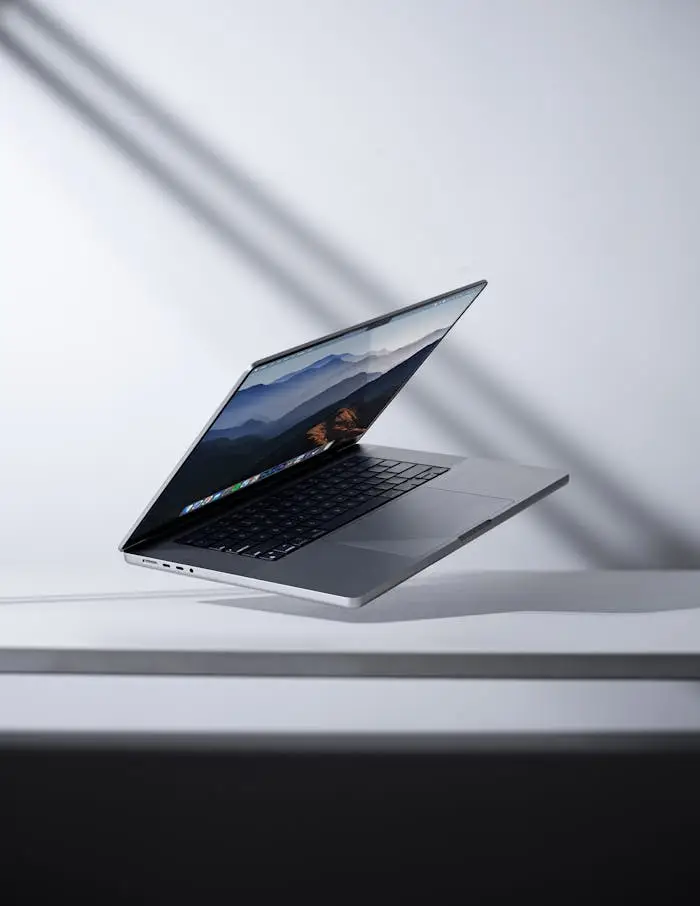 Modern laptop levitating in a minimalist studio setting. Perfect for technology themes.