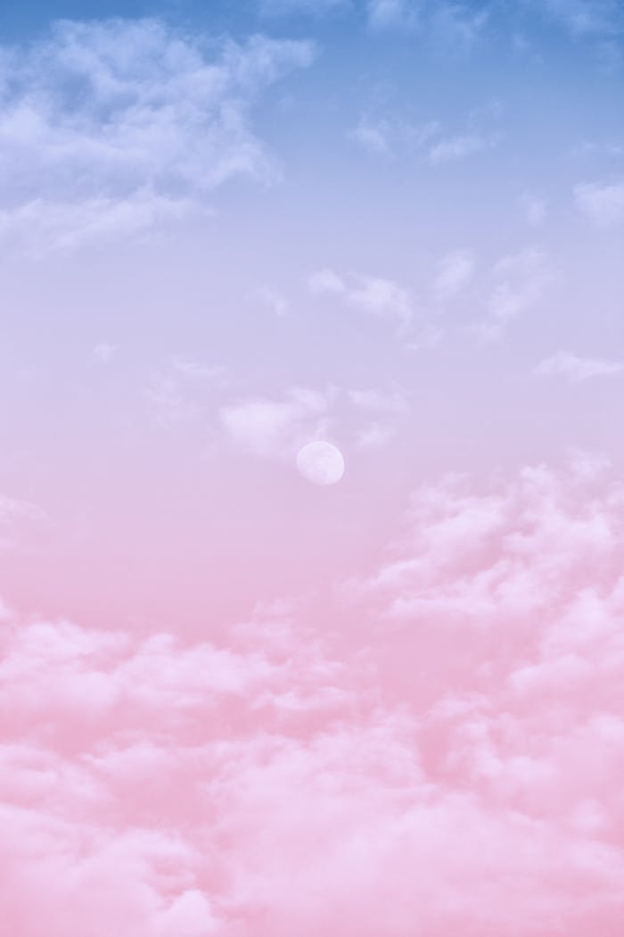 Aesthetic pastel sky with soft clouds and moon, perfect for wallpapers and backgrounds.